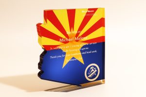 Bright custom printed sign with vibrant red, yellow, and blue colors, featuring personalized text and graphics, ideal for promotional displays, awards, or branding purposes.