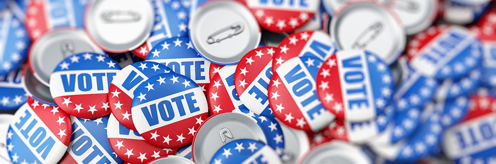 Vote buttons and election campaign pins in red, white, and blue patriotic colors.