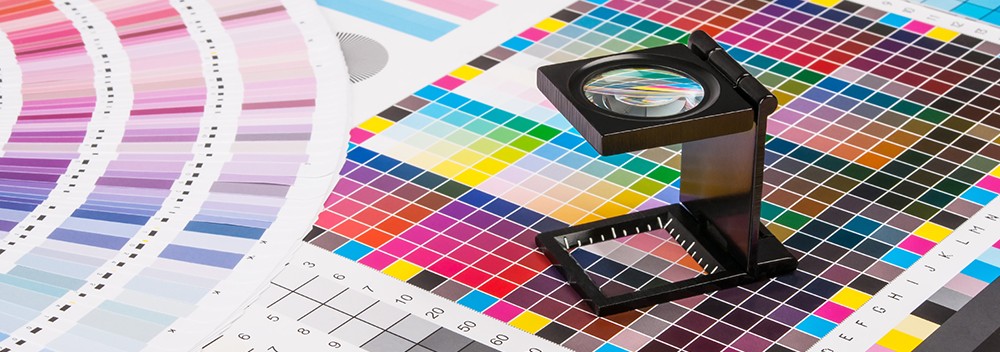 Color calibration and printing sample with color swatches and a magnifying glass for graphic design, printing, or branding projects.