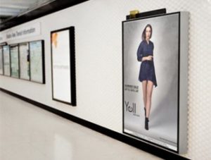 Vibrant digital signs and banners displayed inside a modern showroom, showcasing Graphic Impact's custom signage, engraving, and apparel solutions for branding and marketing.