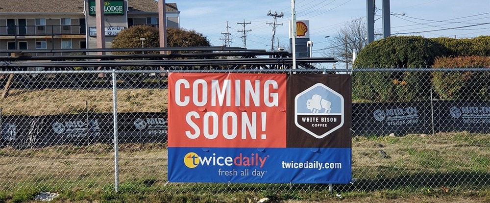 Coming soon banner advertising upcoming business openings at a commercial property.