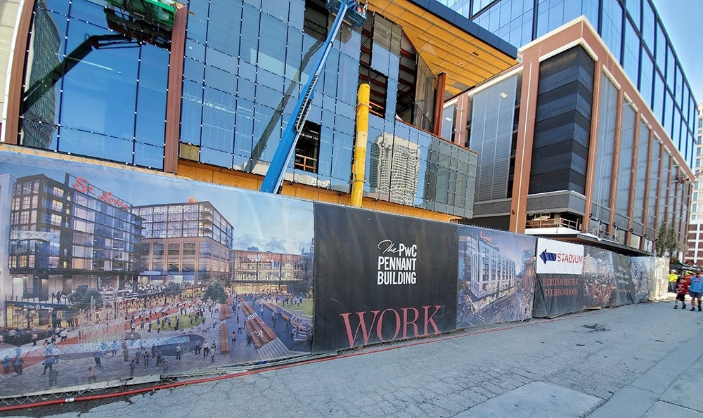 Eye-catching construction site banner showcasing the upcoming PwC Pennant Building project with vibrant graphics and branding for effective advertising.
