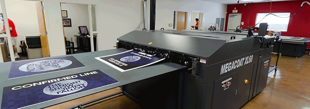 Large format printing machine at Graphic Impact for signs, banners, and custom graphics production, showcasing professional printing equipment in a commercial print shop.