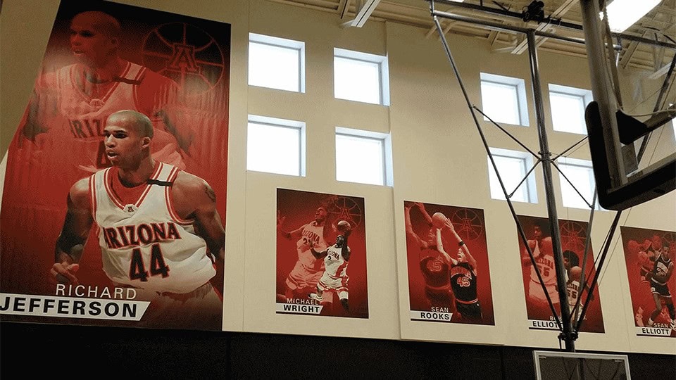 High-quality sports banners featuring iconic Arizona Wildcats basketball players displayed indoors, showcasing custom team branding and vibrant printing for events and promotions.
