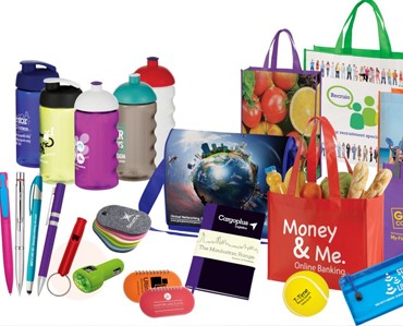 Vibrant assortment of custom signs, banners, engraved items, and promotional apparel from Graphic Impact, showcasing personalized marketing and branding solutions for businesses.