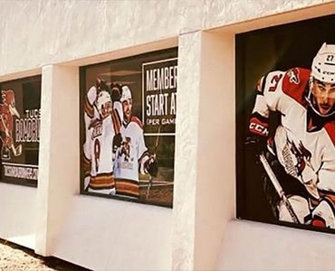 High-quality hockey team photos displayed in frames at Graphic Impact, showcasing custom signs, banners, and sports memorabilia engraving services for sports organizations and fans.