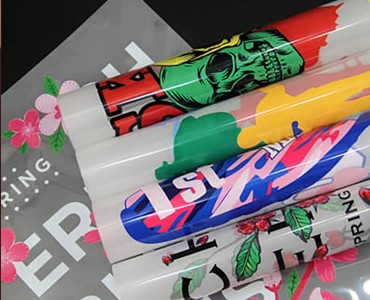 Colorful custom printed banners and signs with vibrant graphics including skulls, flowers, and text showcasing print quality and design detail.