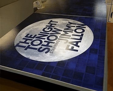 Brightly illuminated promotional floor graphic for the Showtime starring Jamie Foxx, featuring bold text and a circular design, designed to attract attention and enhance event branding.