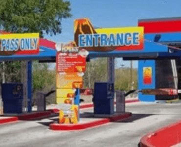 Bright entrance signage with tickets and instructions at an amusement park or entertainment venue.