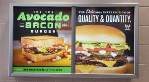 Avocado bacon burger sign, showcasing delicious sandwiches with fresh ingredients, promoting quality and quantity, ideal for restaurant advertising and menu boards.