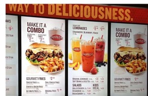 Bright digital signage showcasing menu options, featuring combos, lemonades, salads, and sides with clear, colorful images and prices for quick customer selection.