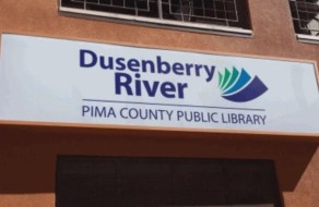 Dusenberry River Pima County Public Library sign showcasing the library’s name with a vibrant logo, designed for visibility and public awareness.