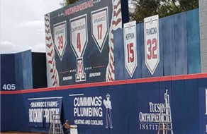 Brightly colored scoreboard with team scores and logos, featuring professionally printed banners and signage for sports events, customized for athletic facilities.