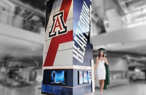 University of Arizona Wildcats promotional banner with digital screens at an indoor event space, highlighting custom signs, banners, and branding solutions.