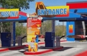 Colorful entrance sign for an amusement park or entertainment center featuring ticket booths and directional signage.
