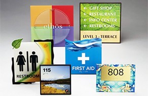 Bright and clear signs for restrooms, first aid, room numbers, and directions, ideal for public spaces, manufactured by Graphic Impact for effective communication.