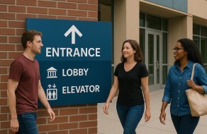 Outdoor signage for building navigation showing entrance, lobby, and elevator info with icons.