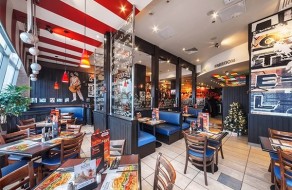 A lively restaurant featuring colorful decor, contemporary lighting, and well-set tables perfect for guests to enjoy meals in a vibrant environment.